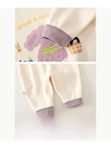 Close-up of ribbed cuffs and cute dog print on cashmere silk baby bodysuit