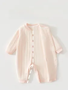 Detail of baby pink bodysuit featuring easy snap buttons and vertical ribbed texture fabric
