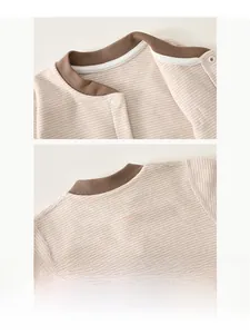 Detailed view of the soft ribbed neckline and snap buttons on a striped baby bodysuit
