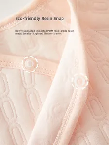 Detail of eco-friendly resin snap buttons on light pink quilted cotton baby romper