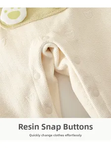 Detailed close-up of resin snap fasteners and quilted fabric on baby winter romper