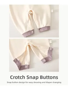 Detail view of baby romper crotch snaps for easy diaper changes in soft knitted fabric