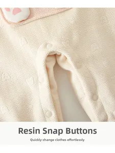Detail of baby romper resin snaps on jacquard fabric with cute bear and paw patterns