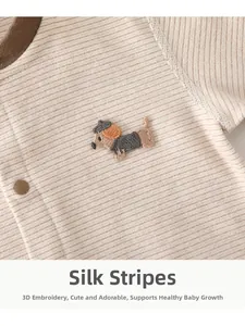 Detail of silk striped newborn romper with dog embroidery and brown snap buttons