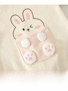 Detail of baby romper featuring thick herringbone knit and 3D bunny embroidery pocket