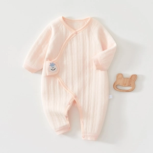 Detailed close-up of pink quilted baby bodysuit with soft texture and smile patch