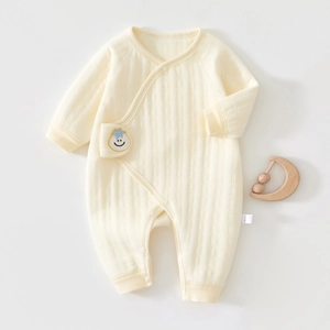 Detailed view of quilted cotton baby romper with smile patch and snap buttons