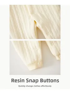Close-up of durable resin snap buttons on a quilted cotton baby romper for easy diapering