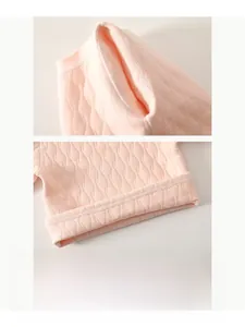 Détail du vêtement matelassé rose pour bébé avec motif losange et couture sans os