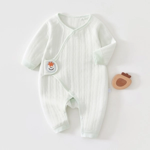 Detail of mint green quilted cotton baby romper with cartoon smiley face embroidery