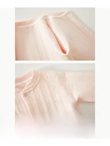 Detail of baby romper showing seamless flatlock stitching and soft pink cotton texture