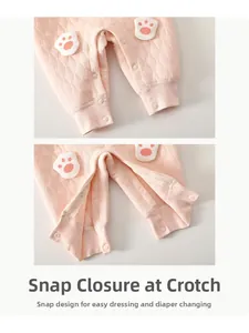 Détail du body bébé rose matelassé avec boutons-pression à l'entrejambe et motif patte de chat