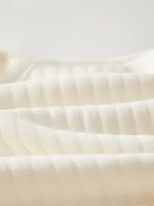 Detailed macro view of soft ribbed cotton fabric on newborn baby warm jumpsuit