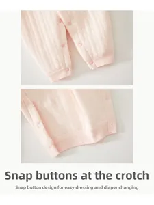 Detail of baby pink knitted romper featuring snap buttons for easy diaper changes