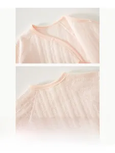 Detail of baby quilted romper showing bound neckline and textured fabric with snap buttons