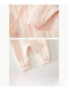 Detail of pink quilted baby romper showing elastic ribbed cuffs and double stitching