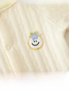 Close-up of quilted baby romper fabric with knit jacquard pattern and smile embroidery