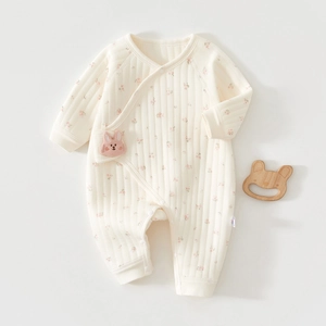 Detail eines Baby-Baumwoll-Stramplers mit Blumenmuster und seitlichem Druckknopf