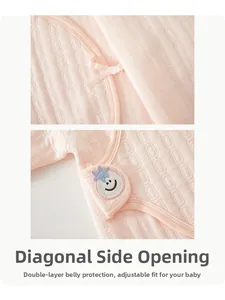 Detailed quilted texture of pink infant bodysuit with secure side-tie and snap buttons