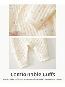 Detailansicht eines Baby-Stramplers mit elastischen Rippbündchen und rosa Blumenmuster