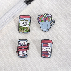 Detailed view of four creative book-themed enamel pins on a white canvas background