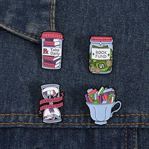 Set of four creative enamel book pins on denim fabric showing artistic literary designs