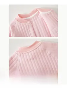 Detail of pink cotton baby romper with soft ribbed texture and white snap buttons