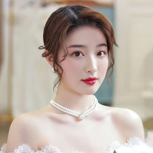 Détail d'un collier de perles double rang et boucles d'oreilles assorties pour mariée