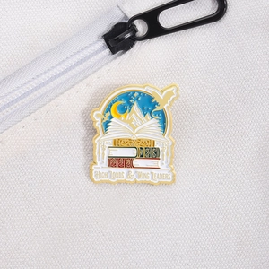 Detailed close-up of High Lords metal enamel pin featuring a dragon and books on a white bag