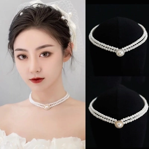 Détail d'un collier de perles à double rangée avec un grand pendentif et bordure métallique