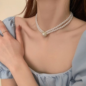 Gros plan d'un collier de perles double couche avec pendentif en strass sur un mannequin