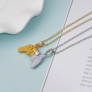 Detail of magnetic game controller pendant set for couples in gold and silver finish