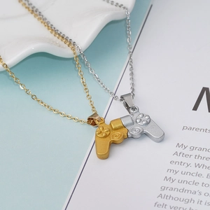 Close-up of matte gold and silver magnetic game controller pendants for couples