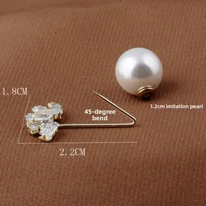 Detailansicht der vergoldeten Sicherheitsnadel-Brosche mit weißer Perle und Zirkonia