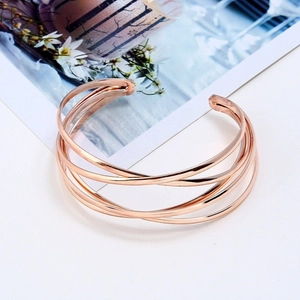 Minimalistischer mehrlagiger Armreif in Roségold mit elegant überlappenden Metallkurven