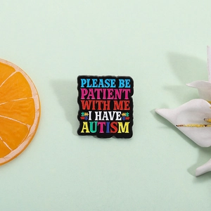 Cartoon enamel pin with Please Be Patient With Me I Have Autism text and puzzle icon