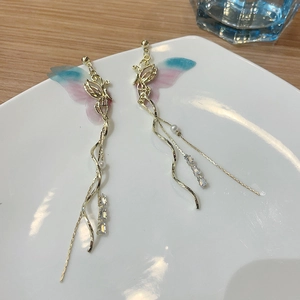 Close-up of golden tassel earrings with gradient butterfly wings and zircon stones