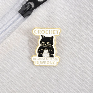 Detailed macro of black cat enamel pin on white fabric showing fine gold metal trim