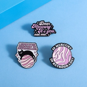 Vue détaillée de broches en émail violet avec chat Mercure et motifs de planètes