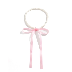 Detail van witte parelhalsketting met een zachte roze zijden strik en lintontwerp