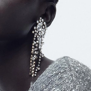 Close-up of elegant long tassel rhinestone drop earrings on model for a luxury look