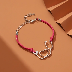 Nurse stethoscope heart pendant bracelet with pink woven cord on artistic background