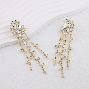 Elegant gold drop earrings with shimmering rhinestone tassels on a clean white display stand