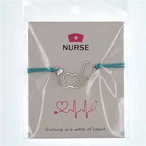 Detailed view of nurse stethoscope heart pendant on blue woven wax cord with backing card