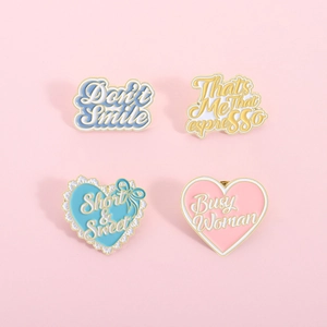 Detail view of four macaron pastel enamel badges with heart and ribbon bow designs