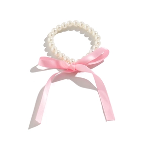 Gedetailleerd zicht op witte parelketting met een lange roze satijnen strik voor dames