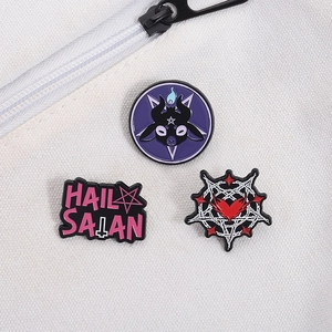 Detailed close-up of gothic enamel pins featuring goat head and satanic pentagram design