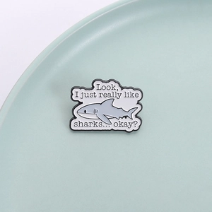 Minimalist shark enamel pin featuring grey shark motif with humorous slogan for shark lovers