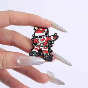 Detail view of a funny dabbing Santa Claus enamel pin with colorful Christmas lights