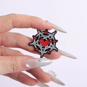 Macro detail of gothic heptagram enamel pin featuring a red heart and white thorns